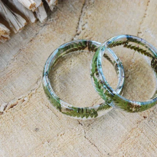 Clear resin fern ring resting on stone surface – handmade botanical accessory