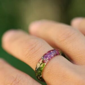 moss and garnet resin ring on finger