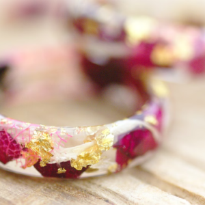 close up of ring made of red roses and white flowers with gold flakes
