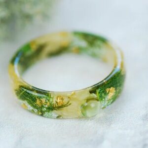 close look at ring made with light jasmine and green peridot