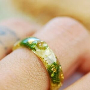 green peridot and jasmine ring on finger