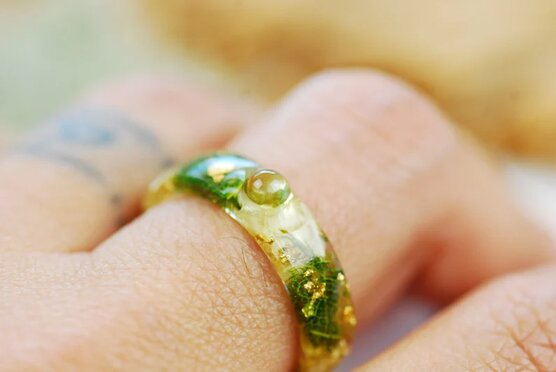 green peridot and jasmine ring on finger
