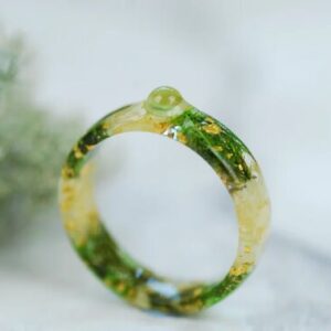 front look at peridot cabochon set in Resin ring with jasmine