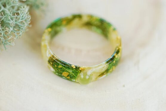 front view of green peridot stone and jasmine petals ring