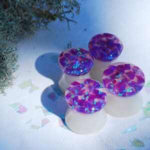 four purple opal ear plugs side by side