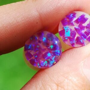Hand holding Purple opal iridescent ear gauges