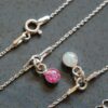 two bracelets with pink and white opal charms