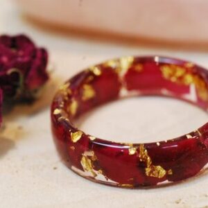 close up of ring made with red rose petals and pure gold