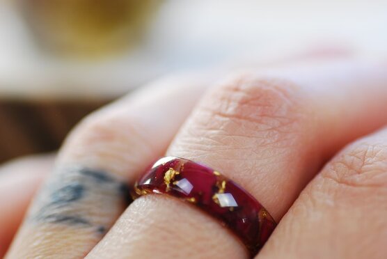 red rose petals and pure fold flakes ring on finger