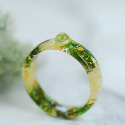 front look at peridot cabochon set in Resin ring with jasmine
