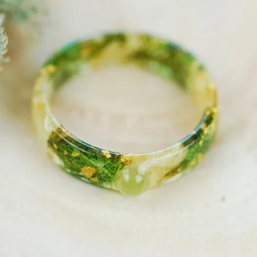 front view of green peridot stone and jasmine petals ring