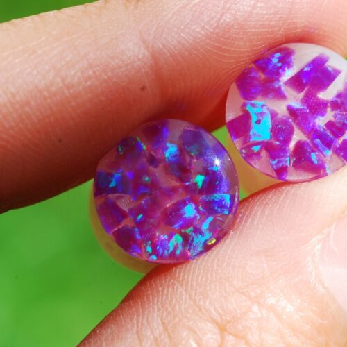 Hand holding Purple opal iridescent ear gauges 