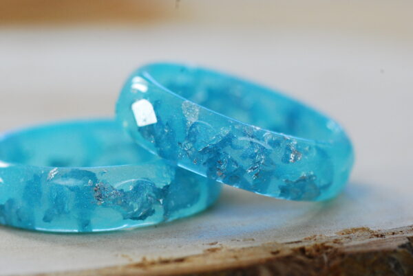 Faceted resin ring in blue pastel color with gold flakes