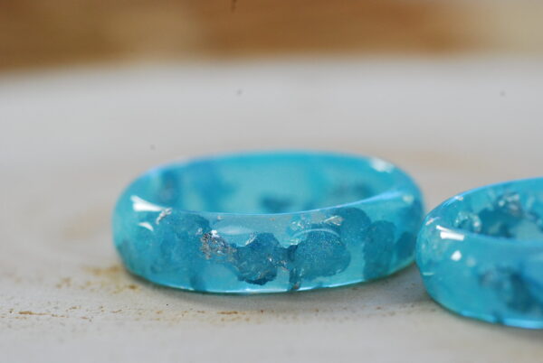 Faceted resin ring in blue pastel color with gold flakes