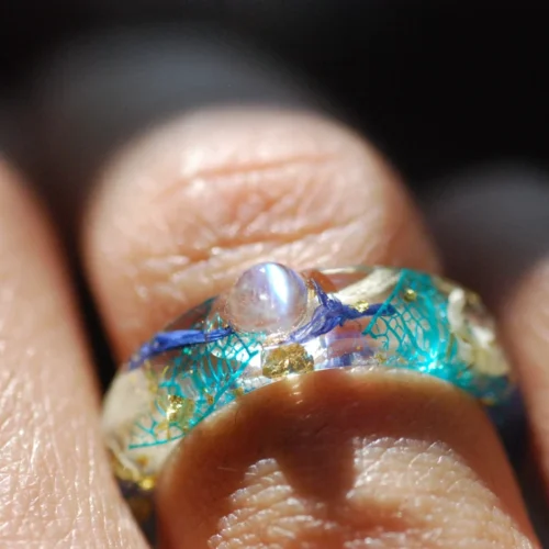 Rainbow moonstone with blue white flowers ring on finger