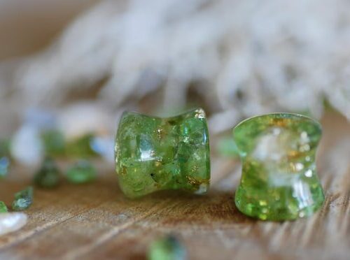 Double flared Clear resin ear gauges with peridot and citrine gemstones inside mixed with 24k gold flakes