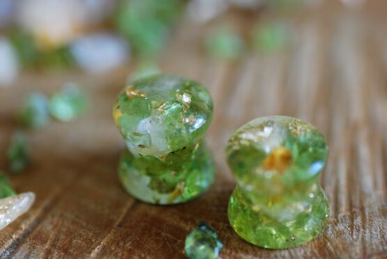 Double flared Clear resin ear gauges with peridot and citrine gemstones inside mixed with 24k gold flakes