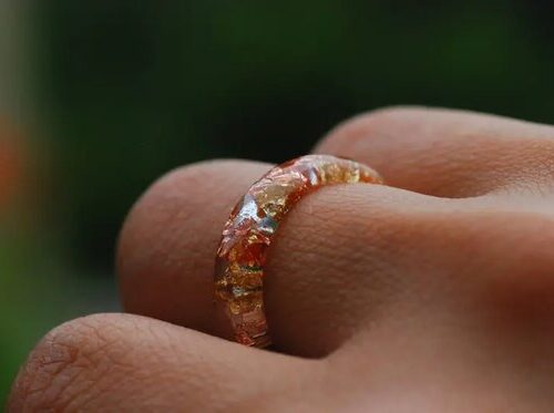 yellow gold and orange copper ring on finger