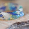 rainbow moonstone resin ring with blue and white cornflower petals
