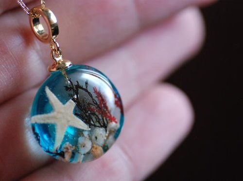 mermaid blue sea necklace in hand