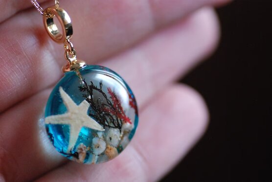 mermaid blue sea necklace in hand