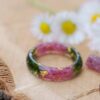 Natural red ruby gemstones with moss and metallic flakes set in a resin ring
