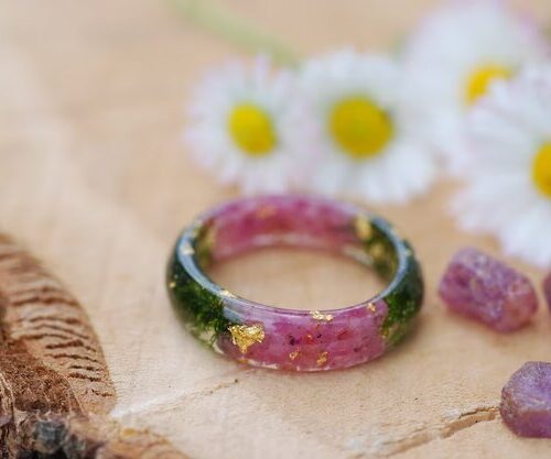 Natural red ruby gemstones with moss and metallic flakes set in a resin ring