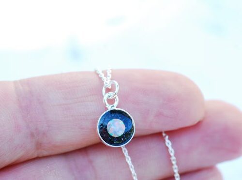 hand holding silver galaxy necklace