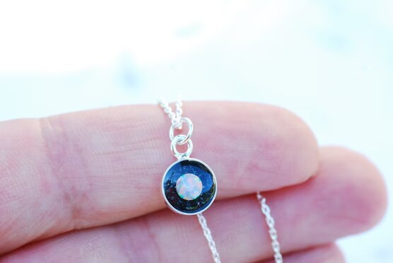 hand holding silver galaxy necklace