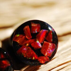 close up at iridescent red fire opal gauges