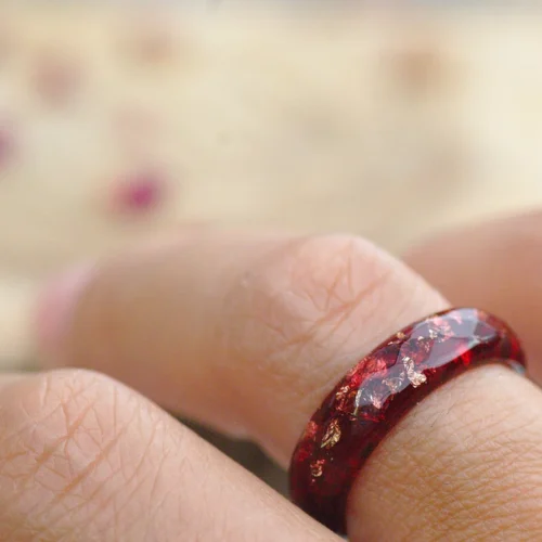 red and gold flakes ring on finger
