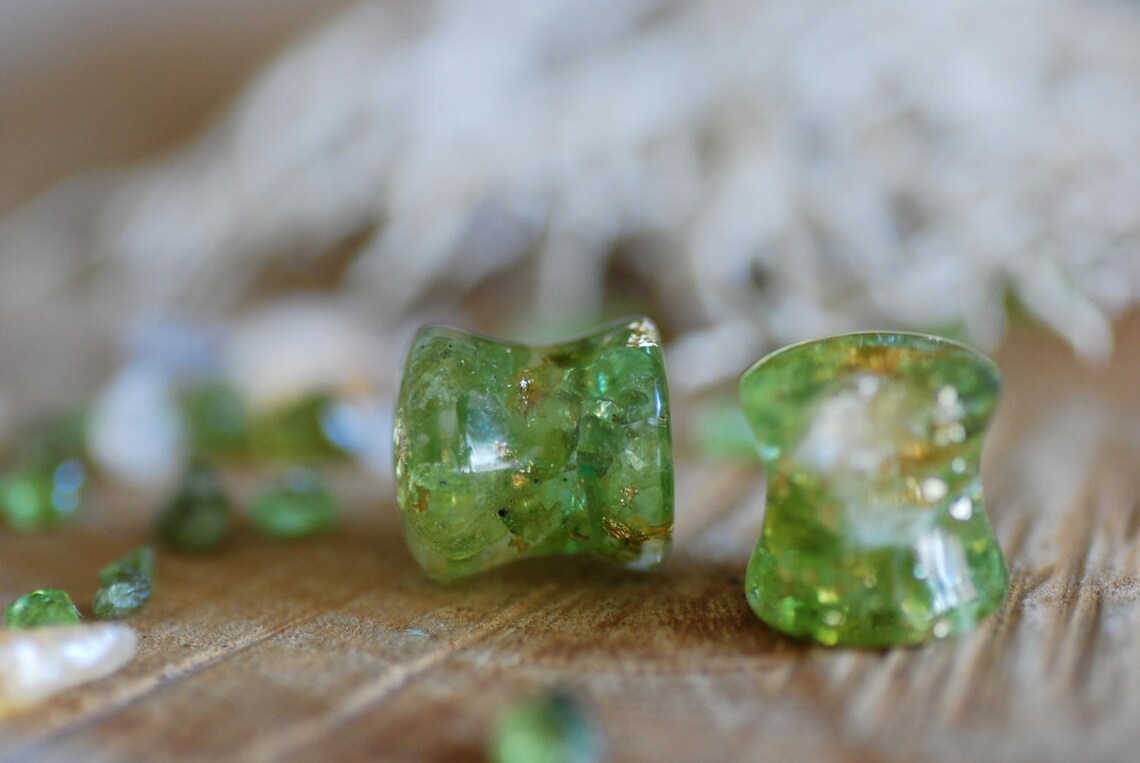 Double flared Clear resin ear gauges with peridot and citrine gemstones inside mixed with 24k gold flakes