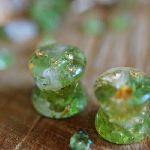 Double flared Clear resin ear gauges with peridot and citrine gemstones inside mixed with 24k gold flakes