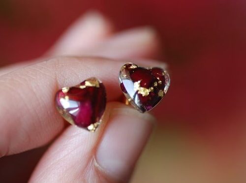 Hear shape post earrings made of resin and filled with red roses and gold flakes