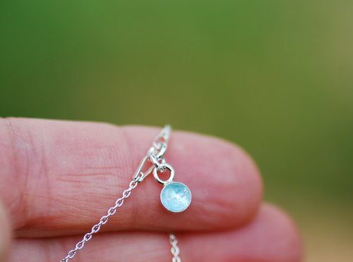 hand holding bracelet with aquamarine gemstone