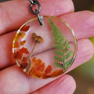 hand holding key ring made with mushroom fern and baltic amber