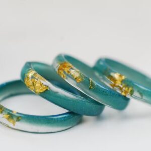 four blue green resin rings with gold