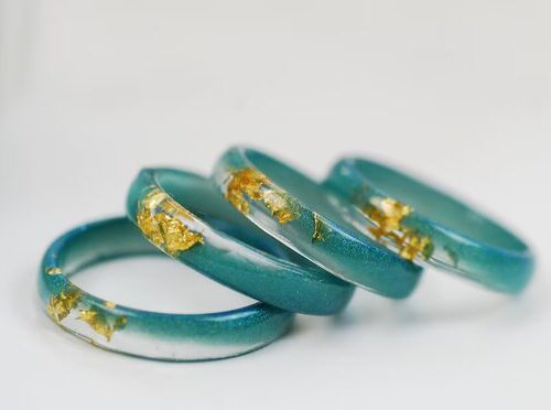 four blue green resin rings with gold