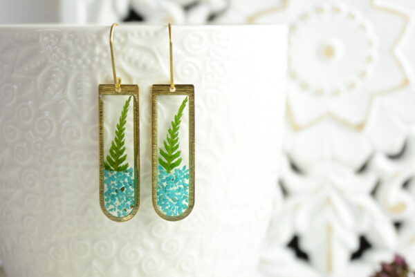 turquoise dangle fern earrings suspended on cup