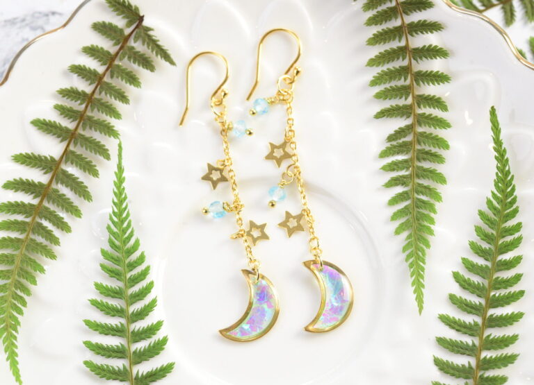 angelic crescent moon earrings between ferns