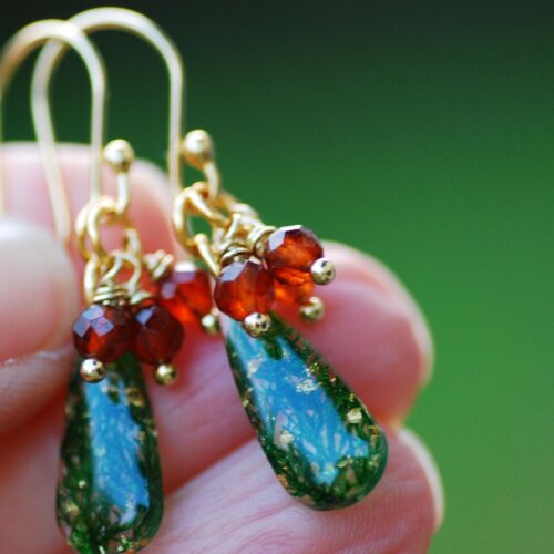 hand holding christmas themed earrings