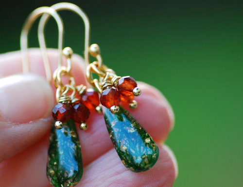 hand holding christmas themed earrings