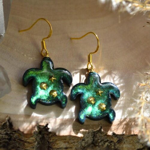 Close‑up of handmade sea turtle ear charms in resin